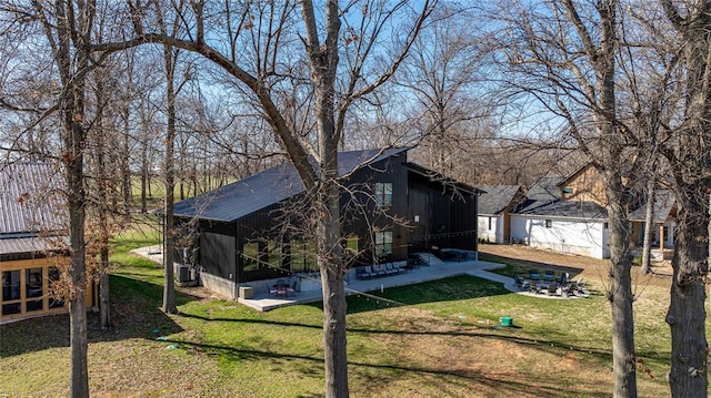 view of property exterior with a lawn and a patio