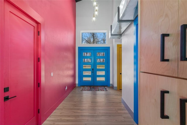 interior space with baseboards, wood finished floors, and french doors