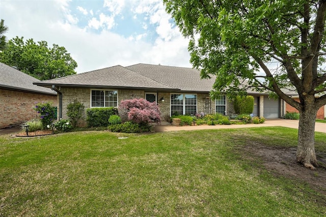 ranch-style home featuring roof with shingles, an attached garage, a front lawn, brick siding, and concrete driveway