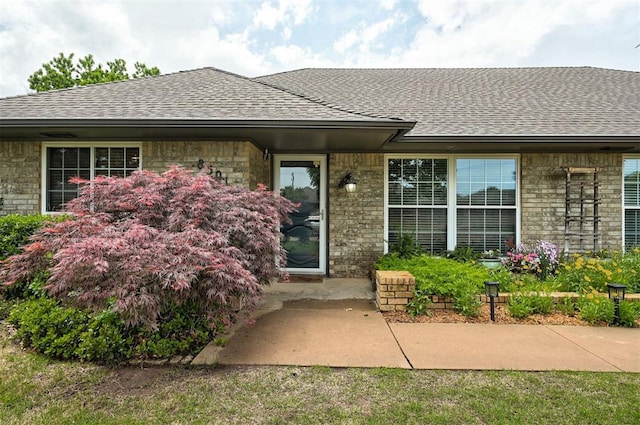 property entrance with brick siding and roof with shingles