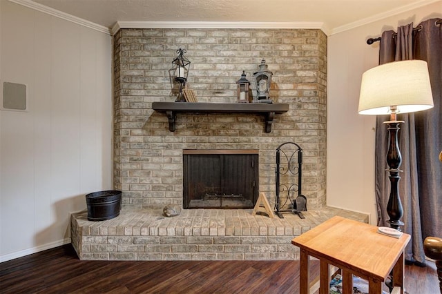 living area with baseboards, ornamental molding, a fireplace, and wood finished floors