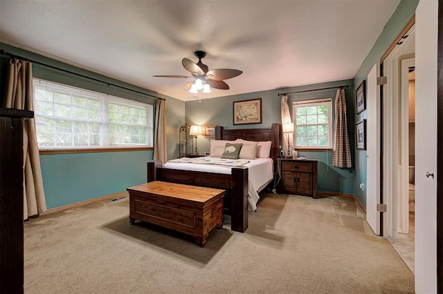 carpeted bedroom with a ceiling fan and baseboards