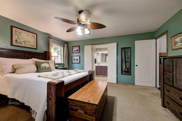 bedroom featuring ceiling fan, light carpet, and ensuite bath