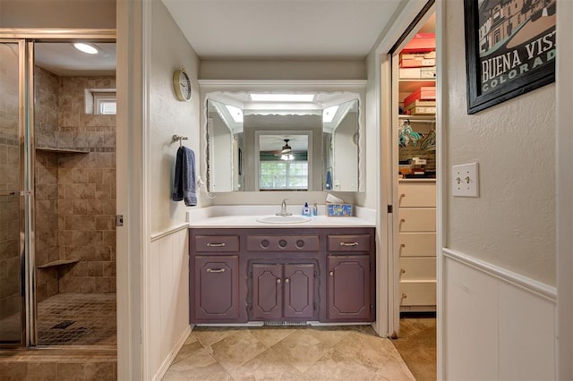 full bath with vanity, a ceiling fan, a stall shower, and tile patterned floors