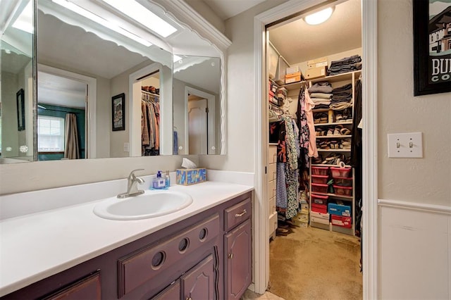 bathroom featuring vanity and a walk in closet