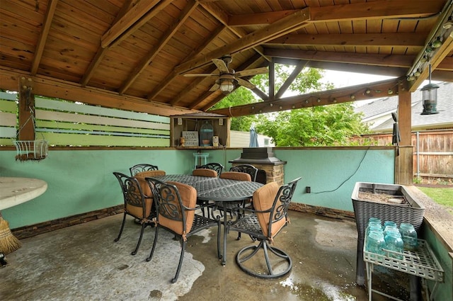 view of patio / terrace with a gazebo, a ceiling fan, fence, and outdoor dining space