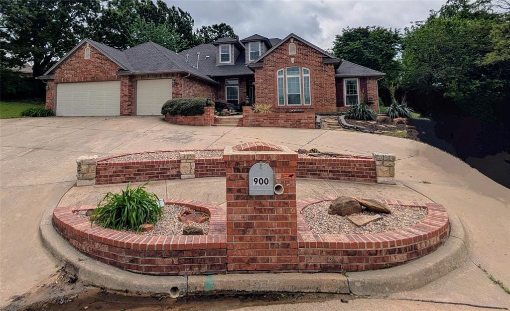 traditional-style house featuring brick siding, a garage, and concrete driveway