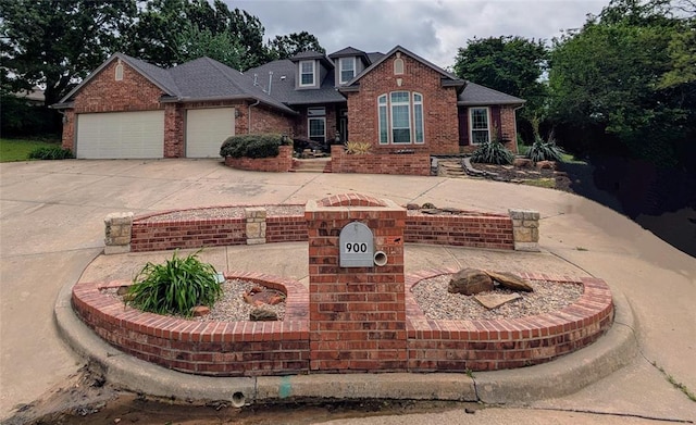 traditional-style house featuring brick siding, a garage, and concrete driveway