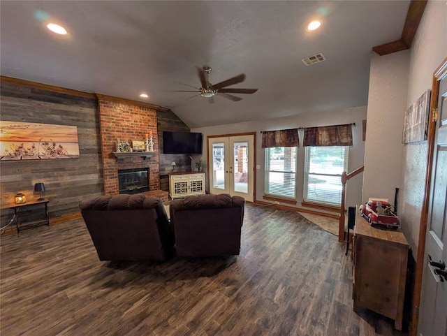 900 Walnut Pl, Norman, OK 73072 - living area with a ceiling fan, vaulted ceiling, wooden walls, dark wood-style flooring, and a brick fireplace
