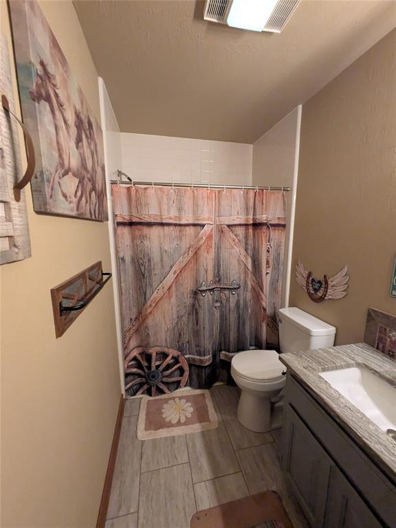 900 Walnut Pl, Norman, OK 73072 - bathroom featuring toilet, vanity, and curtained shower