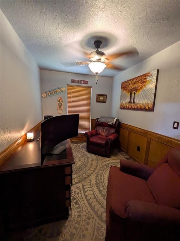 900 Walnut Pl, Norman, OK 73072 - living area featuring a textured ceiling, ceiling fan, and wainscoting