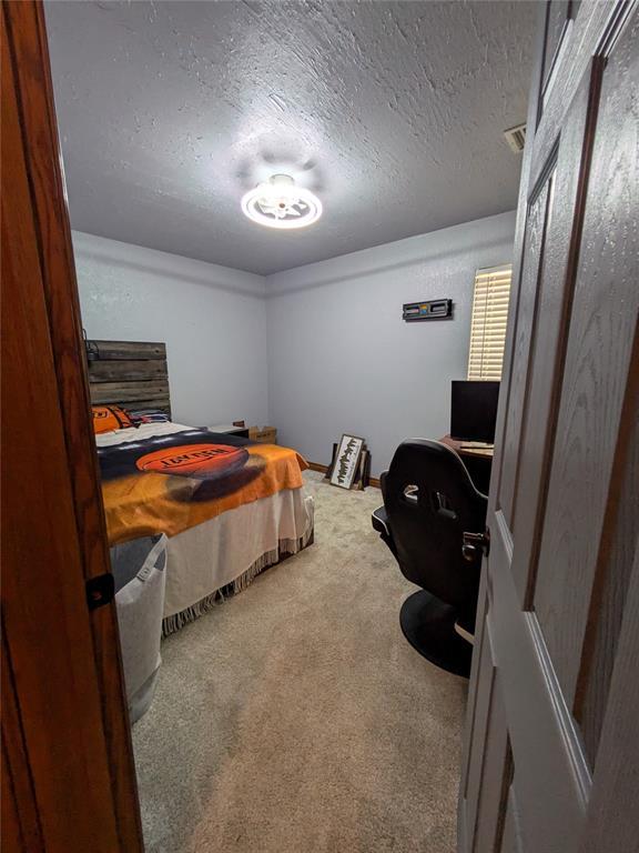 900 Walnut Pl, Norman, OK 73072 - carpeted bedroom featuring a textured ceiling