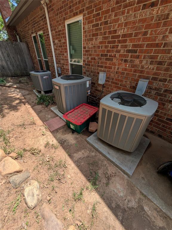 900 Walnut Pl, Norman, OK 73072 - exterior view of central AC unit, brick siding, and fence