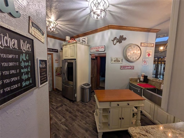 900 Walnut Pl, Norman, OK 73072 - kitchen with stainless steel fridge, crown molding, dark wood-style flooring, a textured ceiling, and a textured wall