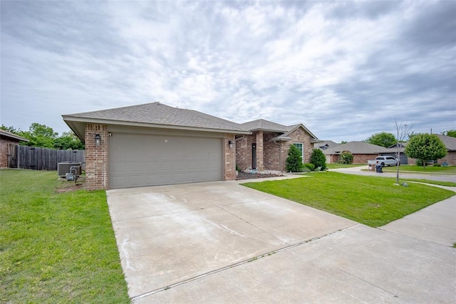 1208 Hickory Creek Dr, Yukon, OK 73099 - ranch-style home featuring a garage, fence, concrete driveway, a front lawn, and brick siding