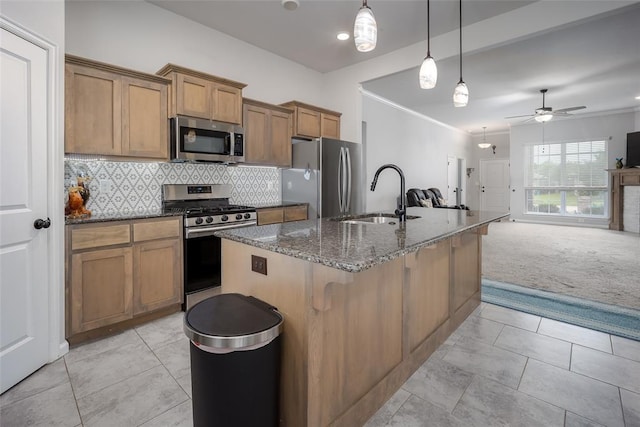 1208 Hickory Creek Dr, Yukon, OK 73099 - kitchen featuring a sink, dark stone countertops, brown cabinets, tasteful backsplash, and appliances with stainless steel finishes