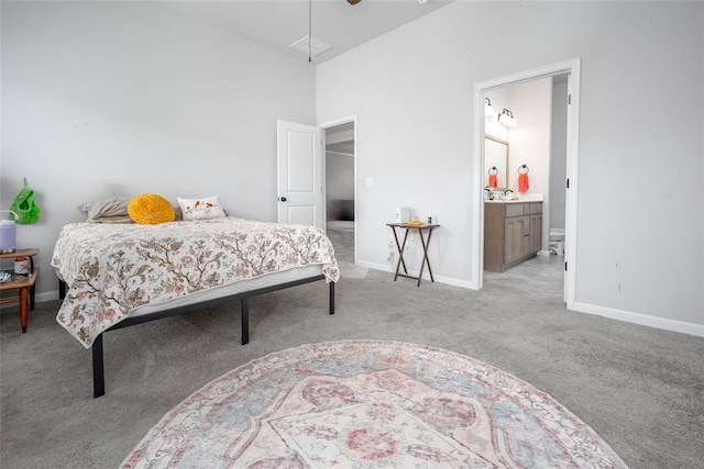 1208 Hickory Creek Dr, Yukon, OK 73099 - carpeted bedroom featuring ensuite bathroom, a towering ceiling, and baseboards