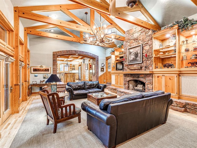 3812 Ridgeline Dr, Norman, OK 73072 - living room featuring a notable chandelier, a fireplace, high vaulted ceiling, and wood finished floors