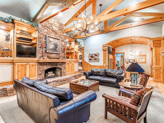 3812 Ridgeline Dr, Norman, OK 73072 - living room with a stone fireplace, an inviting chandelier, a wainscoted wall, arched walkways, and beamed ceiling