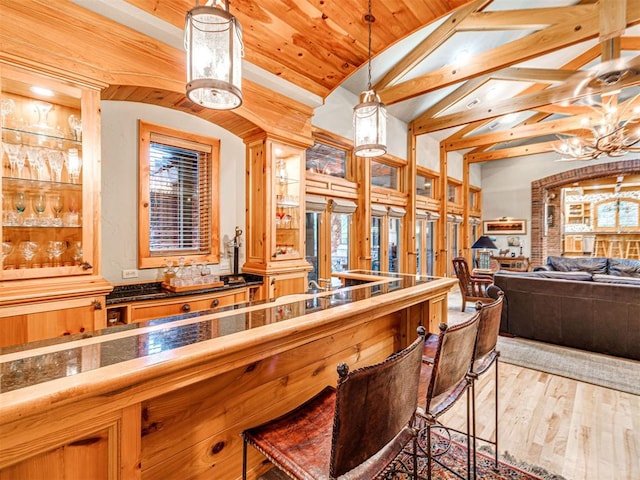 3812 Ridgeline Dr, Norman, OK 73072 - bar with an inviting chandelier, wood finished floors, lofted ceiling with beams, and decorative light fixtures