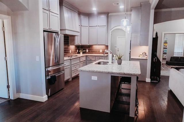 kitchen with baseboards, appliances with stainless steel finishes, ornamental molding, and a sink