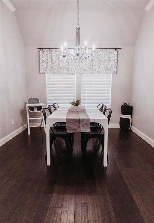 dining room featuring baseboards, wood finished floors, a chandelier, and vaulted ceiling