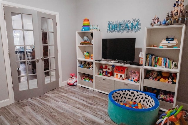 recreation room with french doors, baseboards, and wood finished floors
