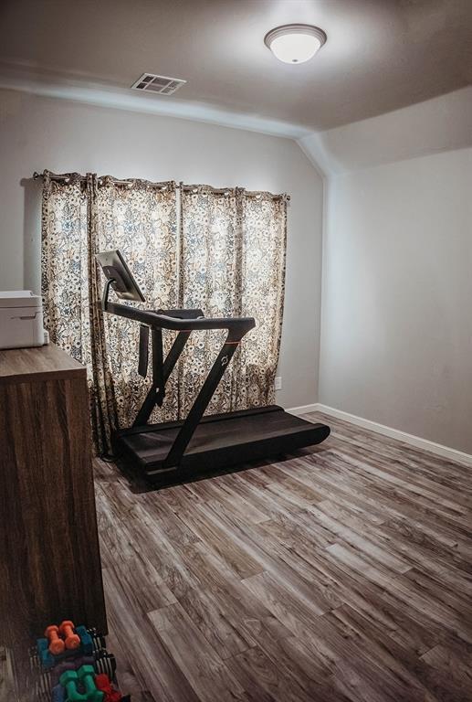 interior space with baseboards, visible vents, and wood finished floors