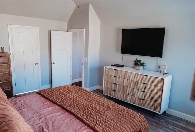 bedroom with baseboards, vaulted ceiling, and wood finished floors