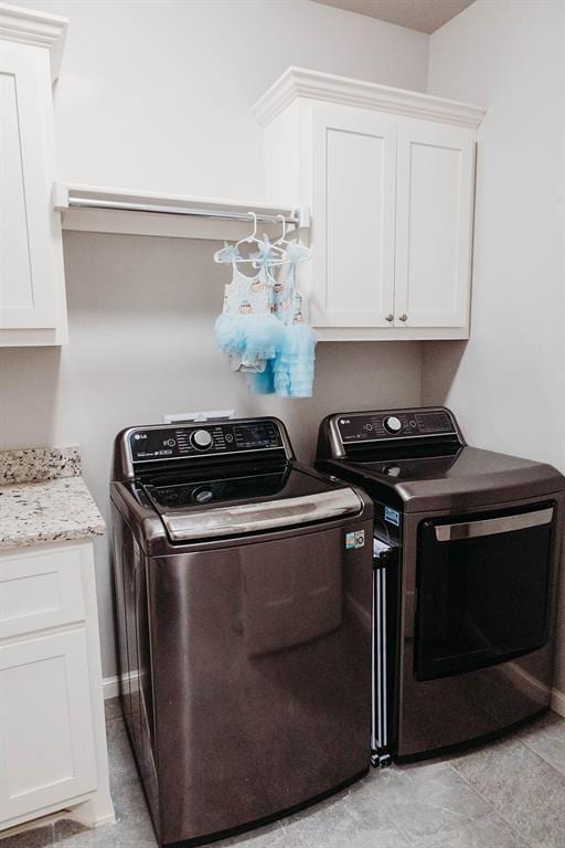 clothes washing area with cabinet space and washing machine and clothes dryer