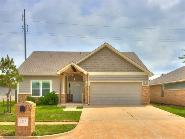 view of front of home with an attached garage, a front lawn, brick siding, and concrete driveway