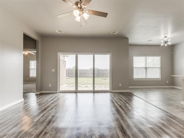 unfurnished living room with visible vents, ceiling fan, and a healthy amount of sunlight