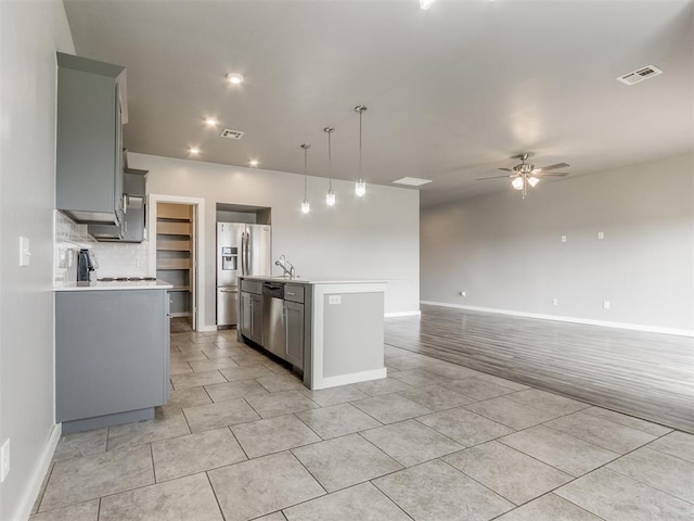 kitchen with light countertops, a ceiling fan, baseboards, and gray cabinetry