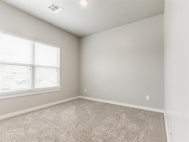 spare room with visible vents, baseboards, and carpet floors