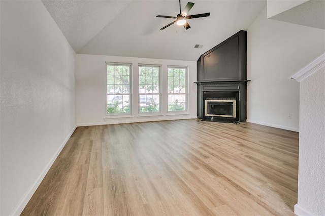 unfurnished living room featuring a fireplace with flush hearth, light wood-style flooring, a ceiling fan, and lofted ceiling