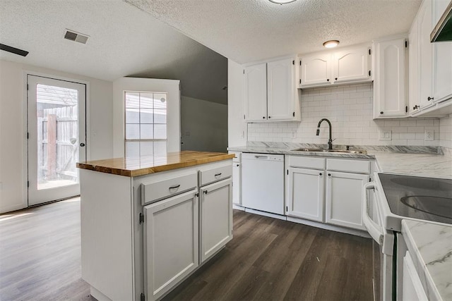 kitchen with visible vents, butcher block counters, white dishwasher, a sink, and dark wood finished floors