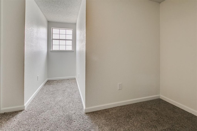 spare room with baseboards and carpet flooring