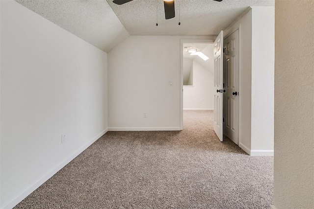 additional living space with ceiling fan, a textured ceiling, vaulted ceiling, baseboards, and carpet flooring