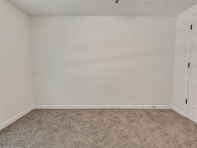 unfurnished room featuring baseboards, carpet, and a textured ceiling