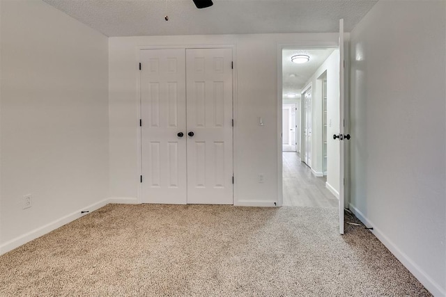 unfurnished bedroom with a ceiling fan, baseboards, carpet, and a closet