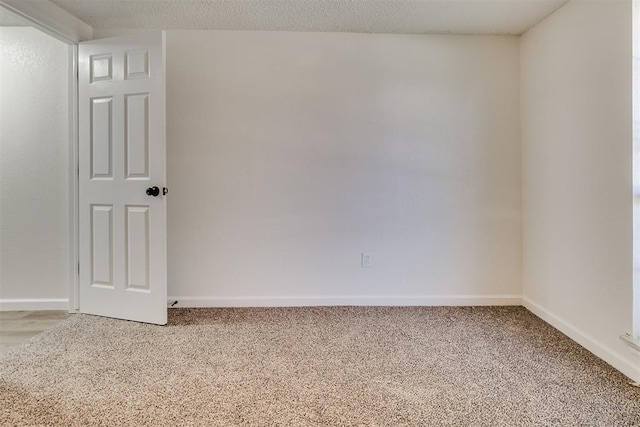 spare room featuring baseboards and light colored carpet