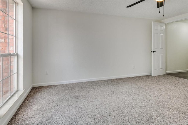 carpeted spare room featuring baseboards and ceiling fan