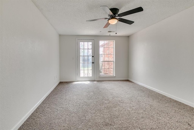 empty room featuring visible vents, baseboards, ceiling fan, a textured ceiling, and carpet