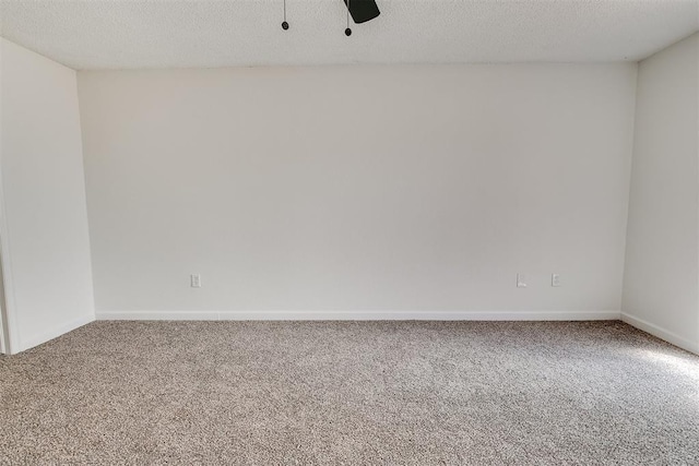 unfurnished room with carpet floors, baseboards, and a textured ceiling