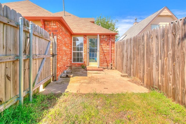 exterior space with a fenced backyard, a patio area, and a gate