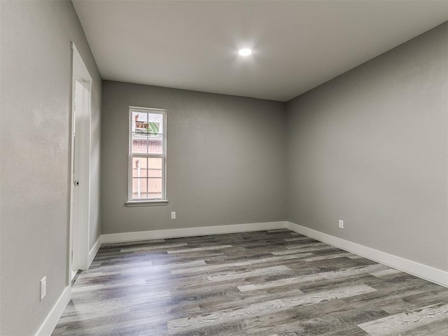 empty room with baseboards and wood finished floors