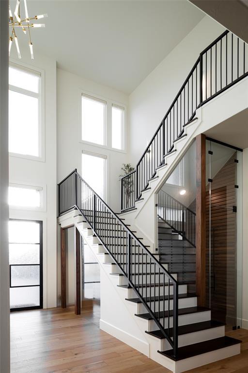 2826 Guilford Ln, Oklahoma City, OK 73120 - stairs with a high ceiling, wood finished floors, a chandelier, and baseboards