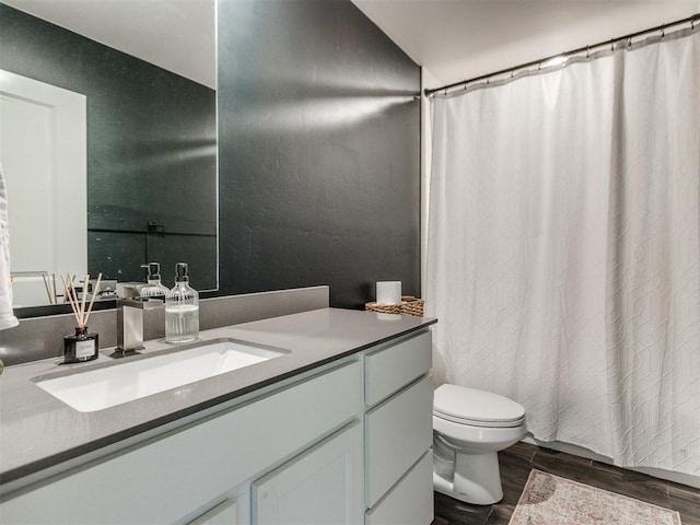 bathroom with vanity, a shower with curtain, toilet, and wood finished floors