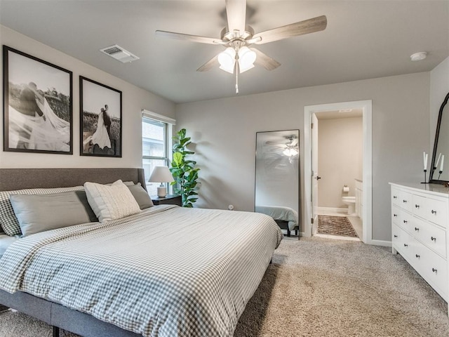 carpeted bedroom with visible vents, connected bathroom, baseboards, and ceiling fan