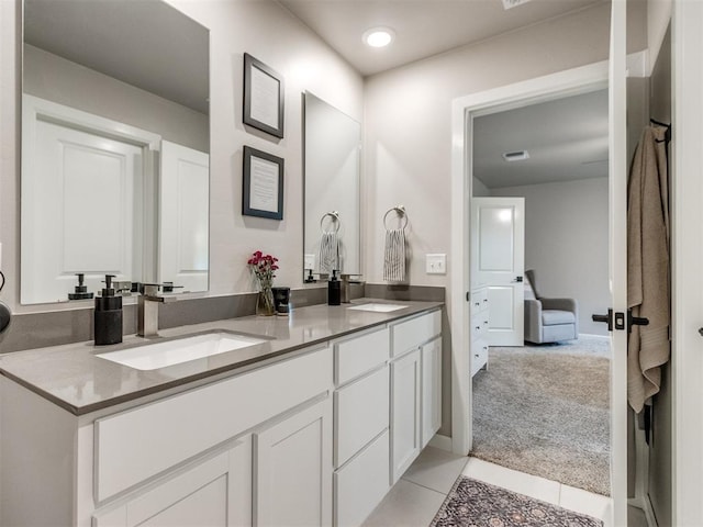 full bath featuring double vanity, a sink, and tile patterned flooring